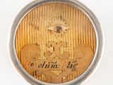 a close up of a gold coin in a silver case