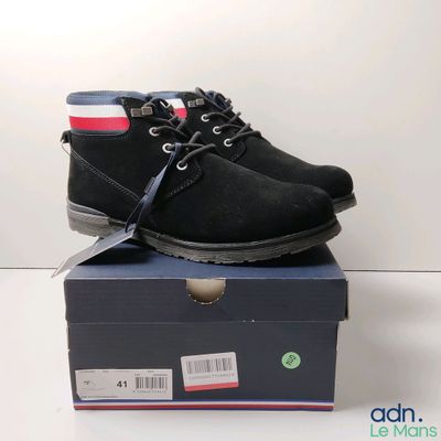une chaussure noire posée sur une boîte