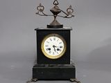 une horloge noire surmontée d'un oiseau