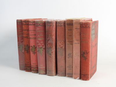 several old books are stacked on top of each other on a white surface