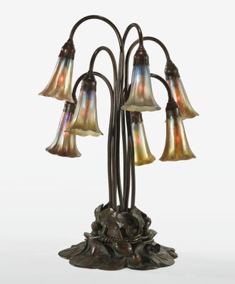 une lampe en bronze et en verre, ornée de cinq fleurs, posée sur un socle