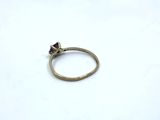 a close up of a gold ring with a purple stone on it
