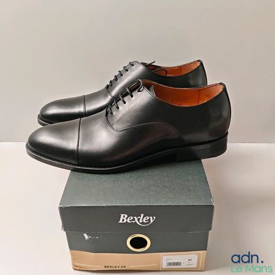 Les chaussures derby noires sont posées sur une boîte