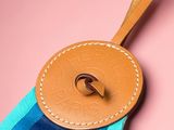 a close up of a blue and brown bag with a leather tag on it