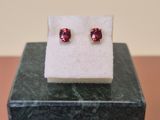 a close up of a pair of earrings on top of a marble block