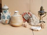 many different vases sitting on a table next to a lamp