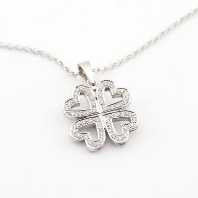 un gros plan sur un collier en argent orné d'un trèfle à quatre feuilles