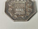 a silver coin with a picture of people on it