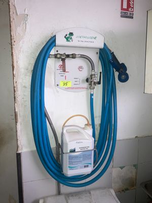 un tuyau bleu raccordé à des toilettes blanches dans une salle de bains
