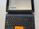 a tablet computer sitting on top of a laptop keyboard