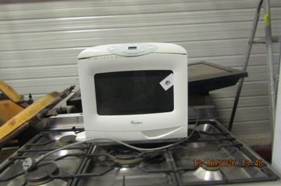 a microwave sitting on top of a stove in a kitchen