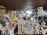 de nombreux objets en verre posés sur une étagère dans une pièce