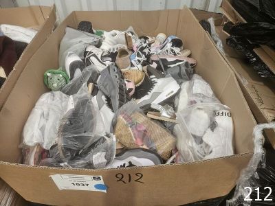 une boîte en carton remplie de chaussures diverses et d'autres objets