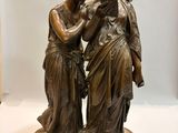 a bronze statue of two women standing next to each other