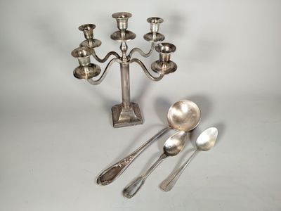 un candélabre en argent avec des cuillères à côté
