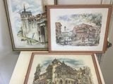 deux aquarelles encadrées représentant des bâtiments anciens, posées sur une table