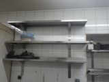 a kitchen with a lot of stainless steel shelvings on the wall