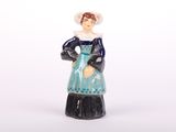 une figurine de femme en robe et chapeau bleus