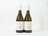deux bouteilles de vin posées l'une à côté de l'autre sur une surface blanche