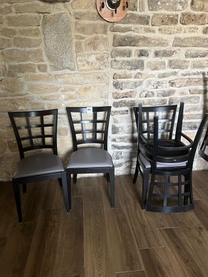 quatre chaises alignées devant un mur de briques