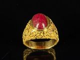 an image of a gold ring with a red stone in the center