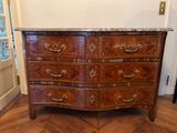 une commode en bois avec un plateau en marbre dans une pièce