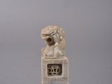 statue of a lion on a pedestal on a gray background