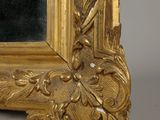 an image of a gold framed mirror on a gray surface