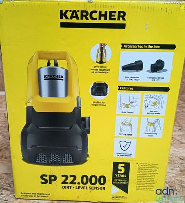 Le carton d'un aspirateur Karcher est ouvert et posé par terre.