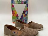 the shoes are on the table next to a box of verbbenas