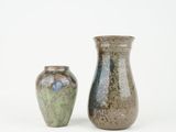 two vases sitting next to each other on a white surface