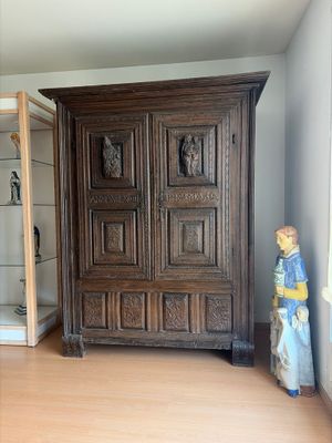 une armoire en bois placée dans un coin de la pièce, près d'une fenêtre