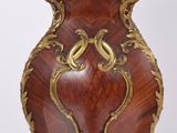 a large wooden vase with a gold decoration on it