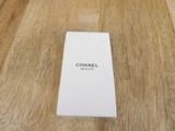 the box of the perfume is sitting on the wooden floor