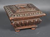 an antique wooden box with a carved design on the lid