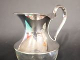 a silver pitcher that is sitting on a table