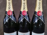 trois bouteilles de champagne Moët posées sur une table