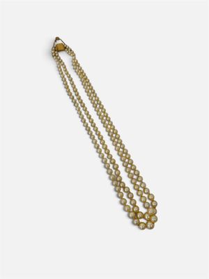 gros plan d'un collier de perles sur fond blanc
