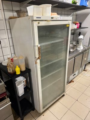a refrigerator in the middle of a kitchen with a lot of food in it