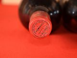 two bottles of wine sitting on a red table