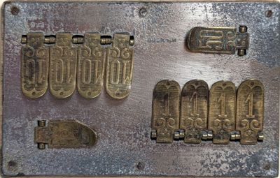 une plaque métallique sur laquelle sont posés tout un tas d'objets métalliques