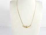 un torse de mannequin blanc orné d'un collier en or