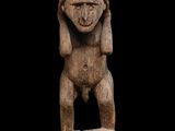 une statue en bois d'un homme avec un chapeau sur la tête