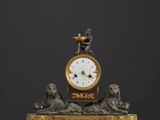 une horloge en or surmontée d'une statue d'homme