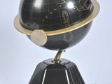 une image représentant un globe terrestre noir et doré posé sur un socle