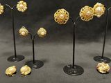 several pieces of gold jewelry are displayed on a black surface