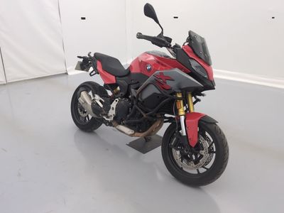 une photo d'une moto rouge et noire dans une pièce blanche