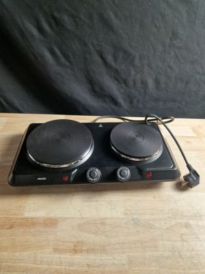 une plaque de cuisson électrique à deux feux posée sur une table en bois