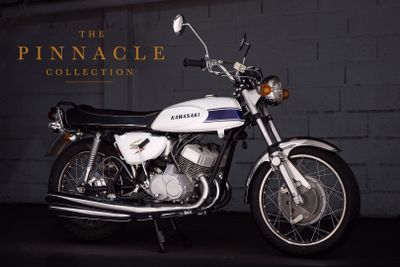 a white motorcycle parked in front of a brick wall