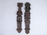 two wooden carvings on the wall next to each other